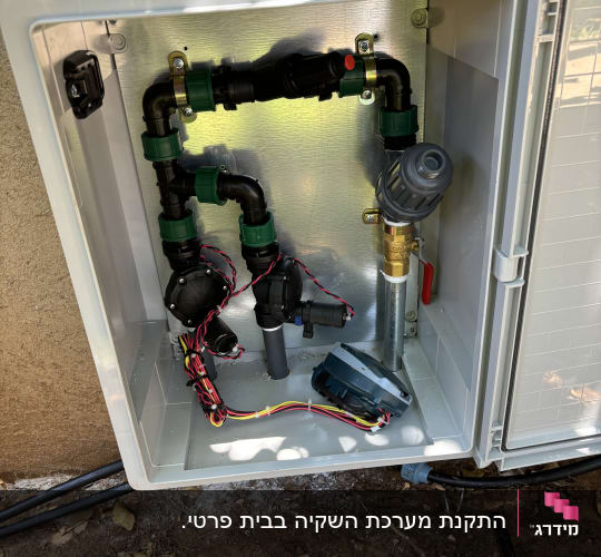 מערכת השקיה עם צינורות ושסתומים בגינה